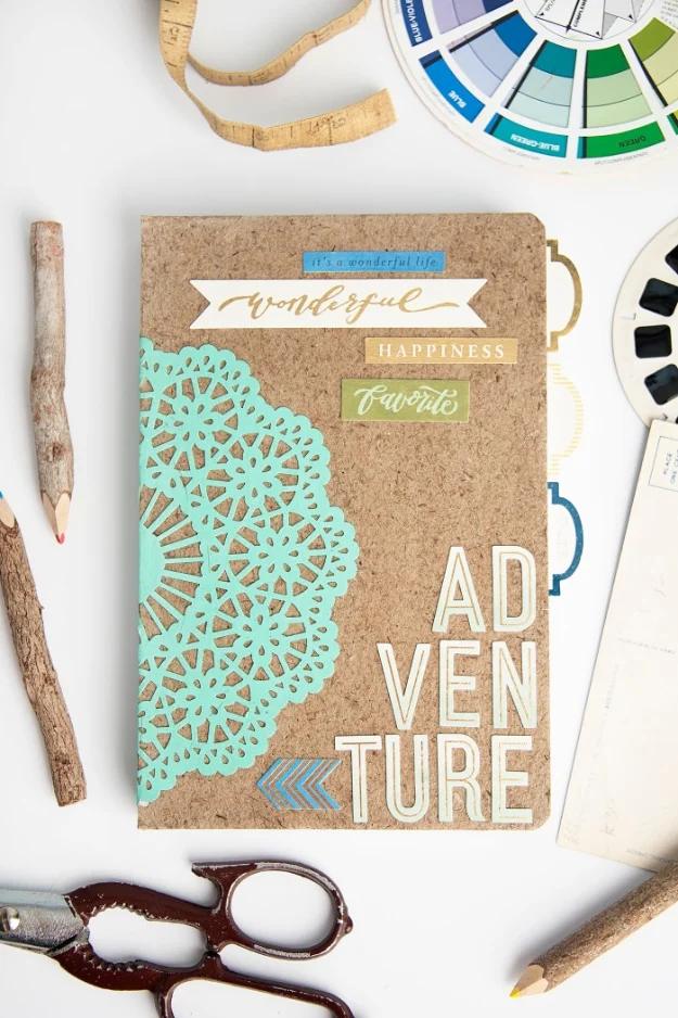 A composition notebook wrapped in floral paper and sealed with Mod Podge, sitting on a desk beside a foam brush