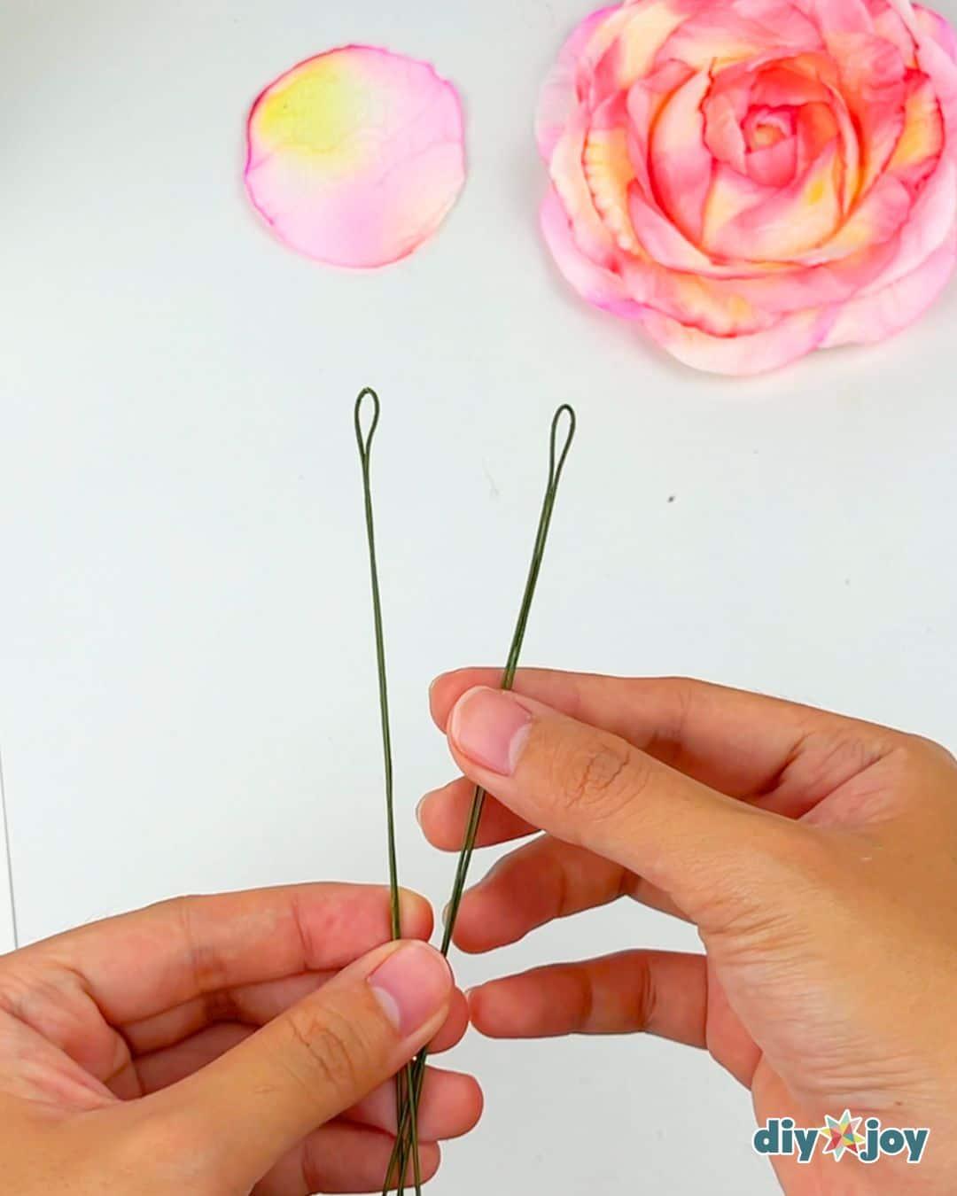How to make flowers using toilet paper, several finished paper roses in soft colors grouped on a surface