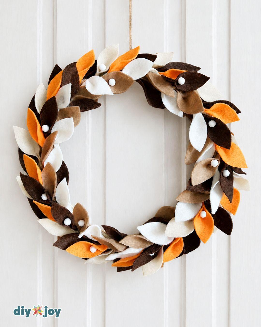 Easy DIY fall wreath tutorial - finished felt leaf wreath with white pom-poms hanging on a door, added for extra texture.