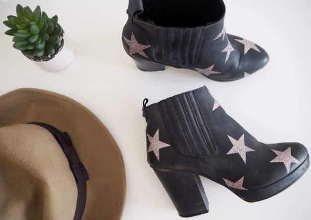 Glitter star boots, black ankle boots scattered with pale pink glitter stars beside a tan felt hat and a succulent