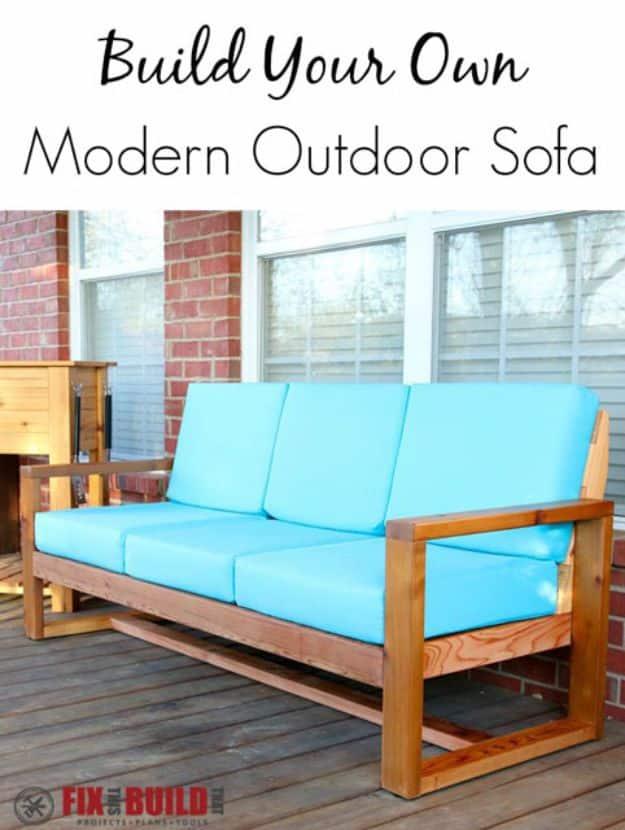 DIY modern outdoor sofa in cedar with bright turquoise cushions on a wood deck against a red brick wall