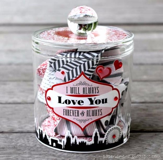 Glass jar filled with folded date night ideas on paper slips as a Valentine's Day wishlist gift in pink and red