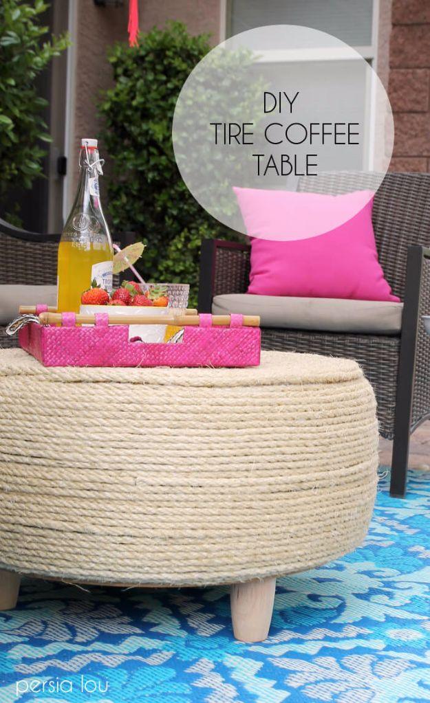 Sisal rope wrapped tire coffee table with short wooden feet on a blue outdoor rug holding a pink tray of fruit