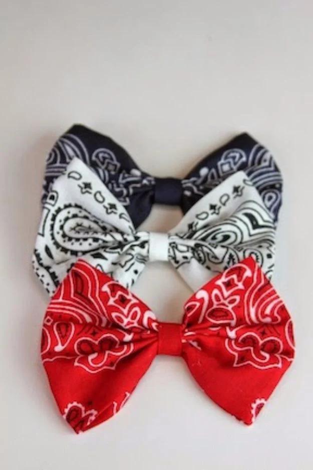 No sew bandana hair bows, three folded bows in navy, white and red stacked on a plain pale background