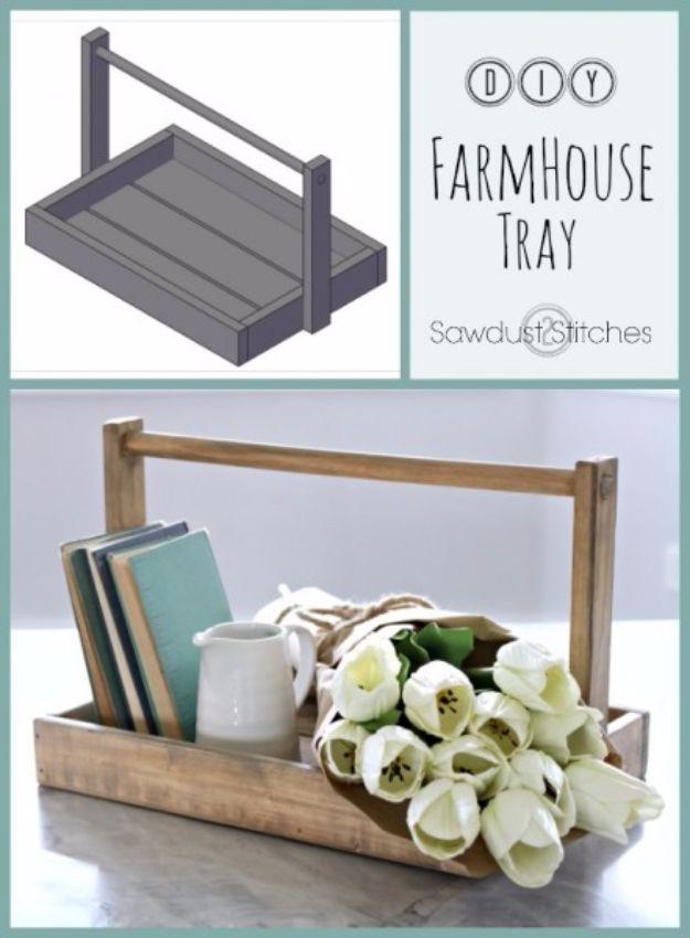 A long narrow wooden tray with metal handles runs down a dining table, holding candles and a sprig of greenery