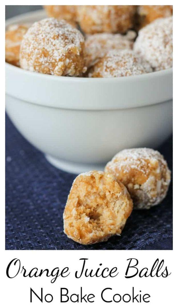 Orange juice balls no bake cookies, powdered sugar dusted cookie balls in a white bowl on navy linen