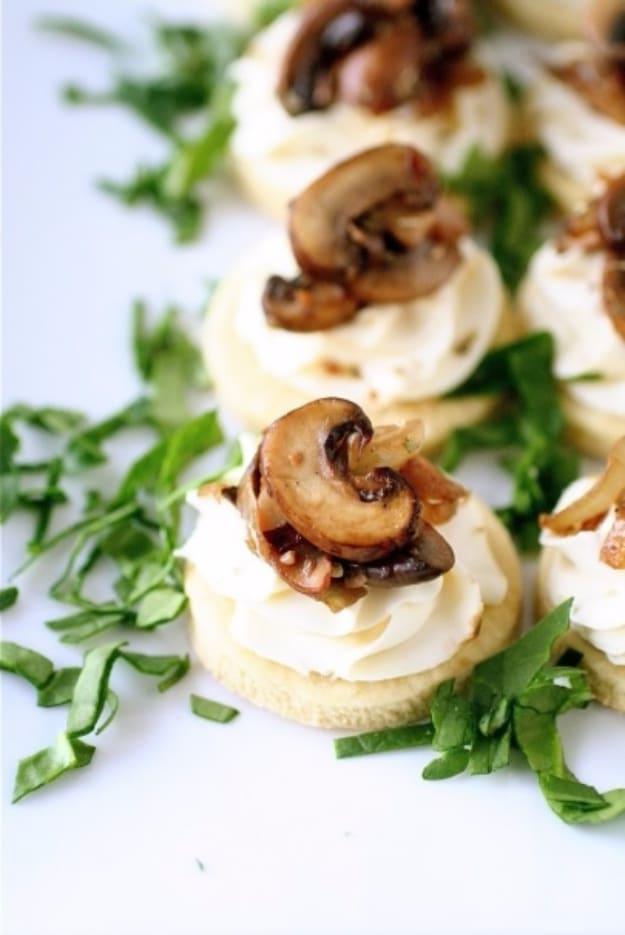 Mushroom and mascarpone tarts in small pastry shells with sauteed mushrooms and fresh thyme on a serving tray