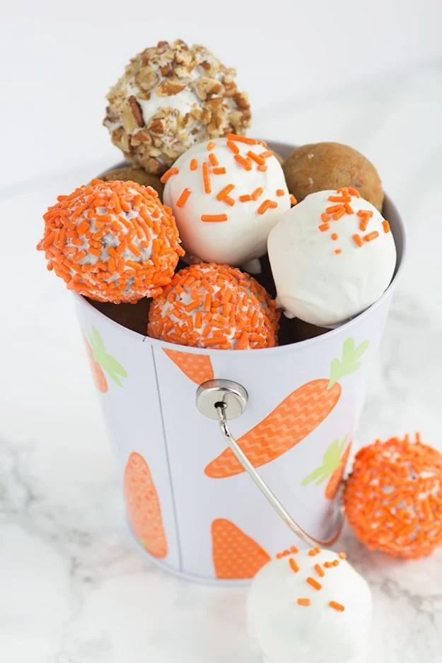 Carrot cake cake pops made with cream cheese frosting and coated in almond bark with sprinkles, cooling on parchment paper