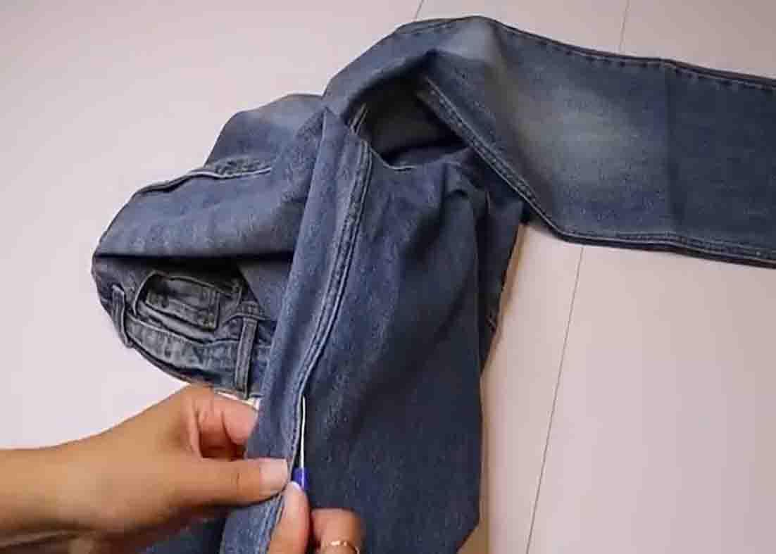 Snipping the seams of the old jeans