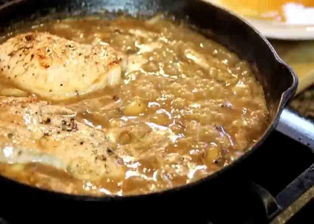 Adding the pork chops to the mushroom and garlic gravy sauce