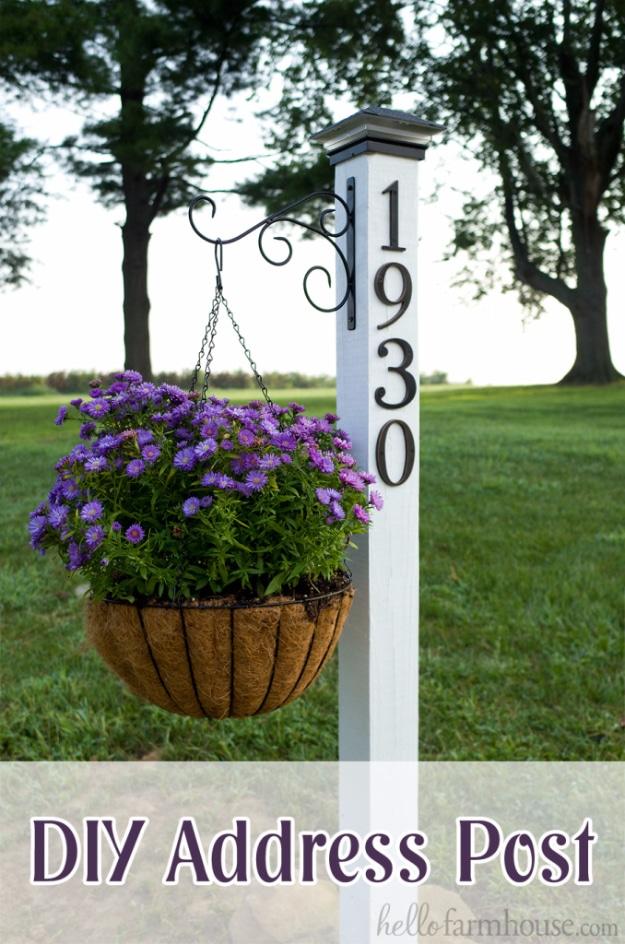 DIY curb appeal address post painted white with vertical house numbers, solar cap and a purple flower hanging basket