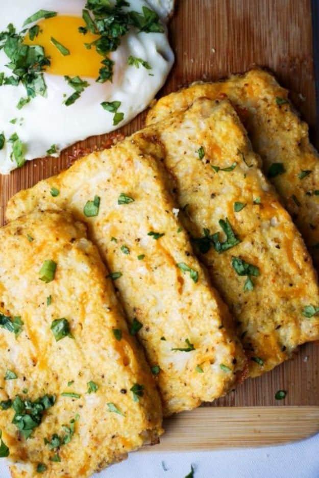 Cauliflower keto hash brown patties on a wooden board with chopped parsley and a fried egg behind them