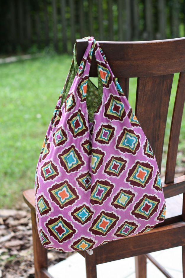 Fat quarter reusable grocery bag in a purple medallion print with a green lining, hung on a wooden chair