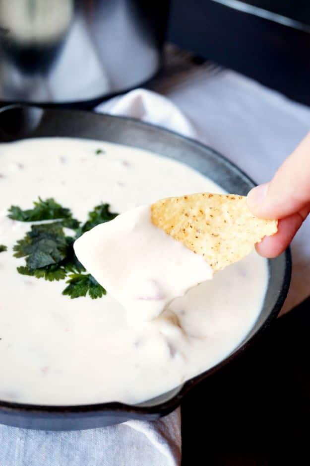 5 ingredient white queso dip poured into a bowl smooth and creamy beside a pile of warm tortilla chips