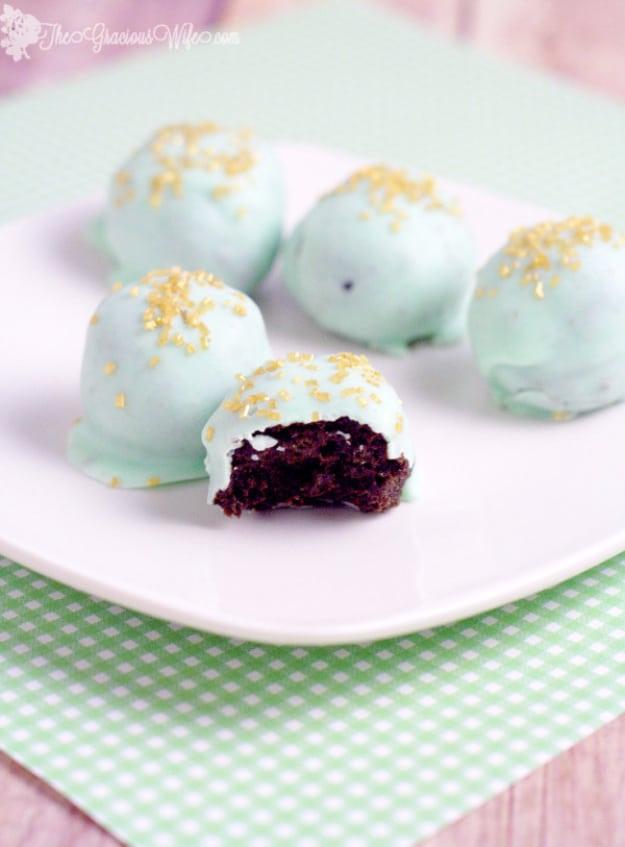 Mint Oreo truffles coated in chocolate with a white drizzle, a no bake dessert idea for parties and gifting