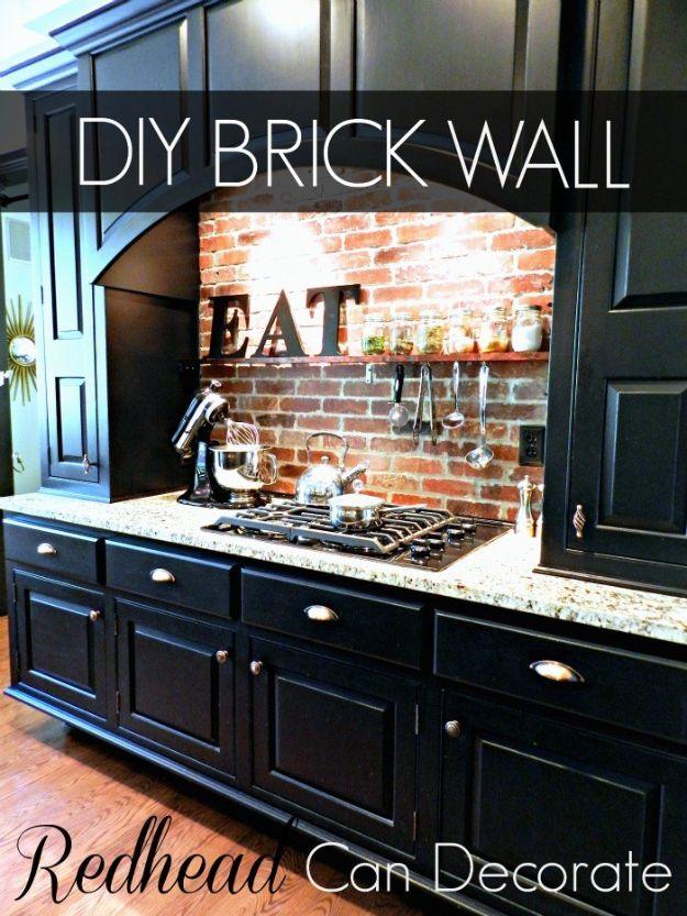 Kitchen with a real brick backsplash behind a range, black cabinets, stone counters and an EAT sign on the wall