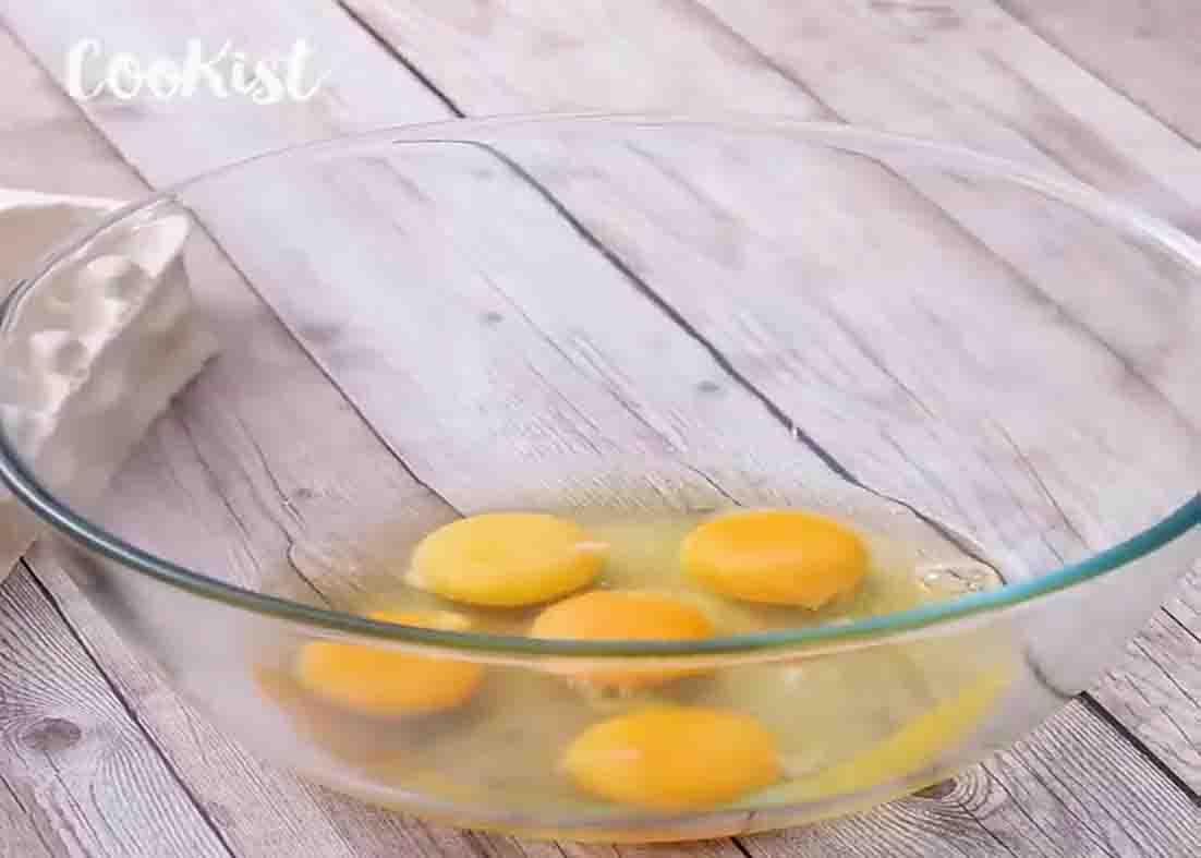 Cracking eggs in a bowl for the creamy cake recipe