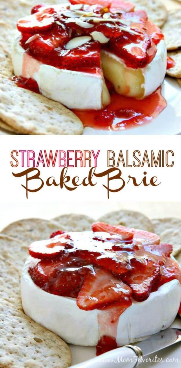 Baked brie wheel topped with red strawberry balsamic sauce and sliced strawberries served with crackers