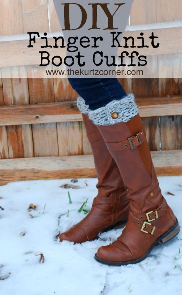 Grey finger knit boot cuffs with a wooden button showing above tall brown leather riding boots standing in snow