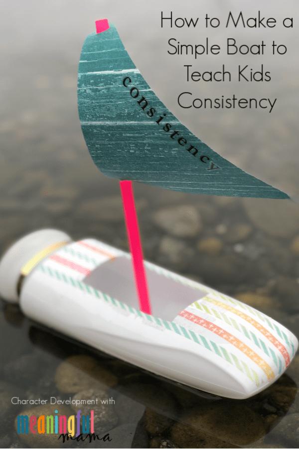 A toy boat made from a lotion bottle wrapped in washi tape with a pink straw mast and a teal paper sail floating on water