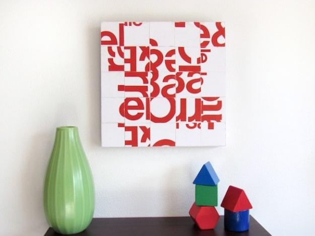 Junk mail typography collage art, a square wall plaque of red and white letter squares in a grid above a green vase