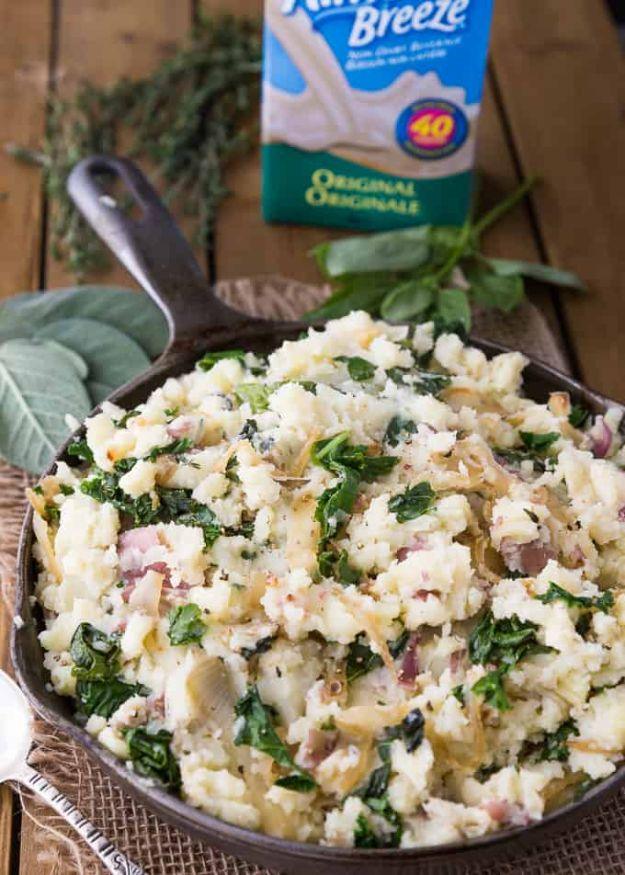 Olive oil mashed potatoes with chopped kale and thyme in a black cast iron skillet beside an Almond Breeze carton