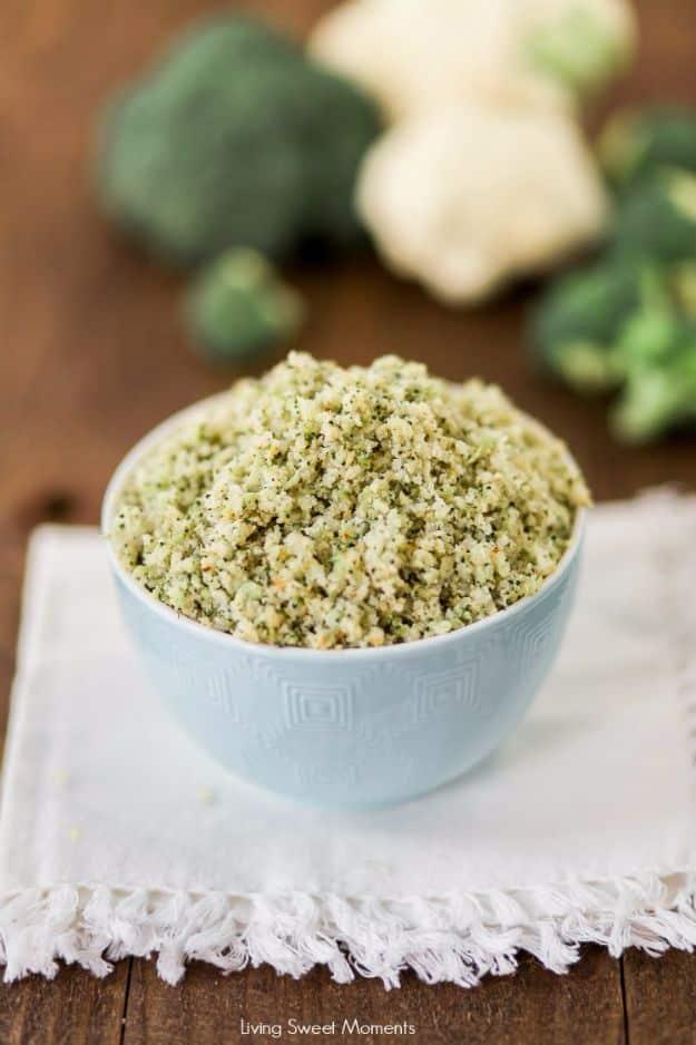 Low carb broccoli cauliflower rice heaped in a pale blue bowl, finely riced and flecked green, whole heads behind it