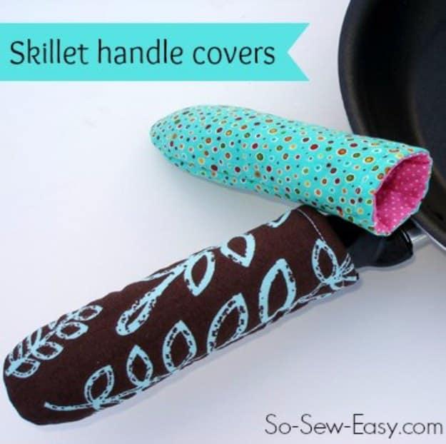 Hot pan or skillet handle cover, two padded fabric sleeves in teal and brown slipped over a black cast iron skillet
