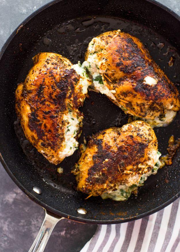 Cream cheese spinach stuffed chicken breasts in a skillet, filling visible along the butterflied edge