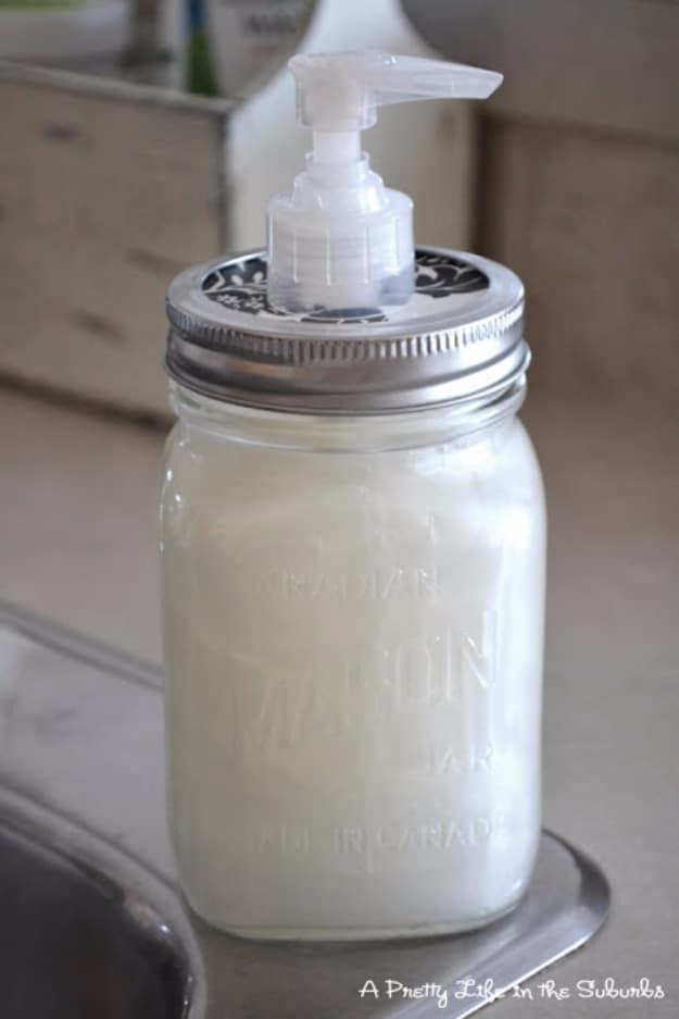 Glass mason jar filled with white liquid soap with a patterned metal lid and a clear plastic pump on a counter