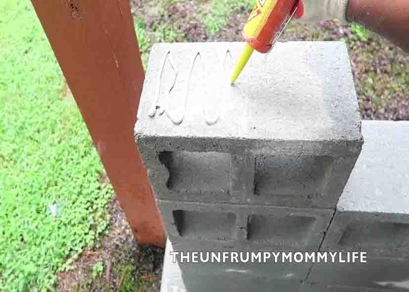 Adding construction adhesive to the cinder blocks