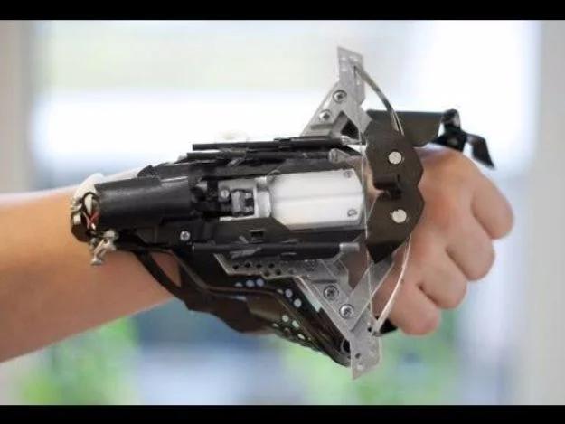 Metal wrist mounted crossbow strapped along a forearm with the bow arms reaching forward past the knuckles