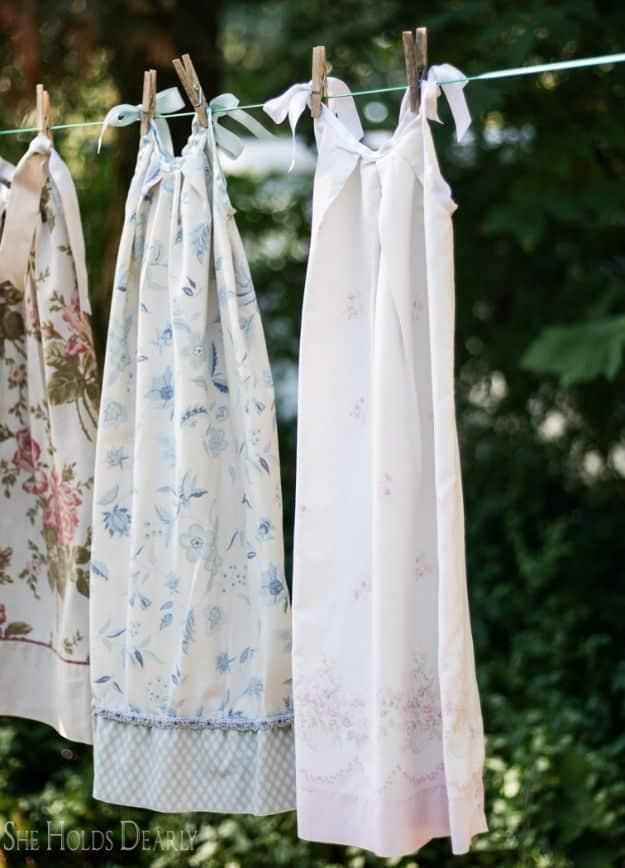 Three floral pillowcase nighties with satin ribbon shoulder ties, hanging from a clothesline outdoors
