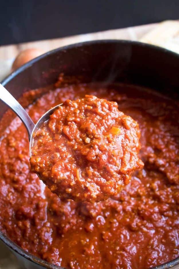Homemade meat sauce simmering slowly with ground beef and Italian sausage in a thick and rich tomato base