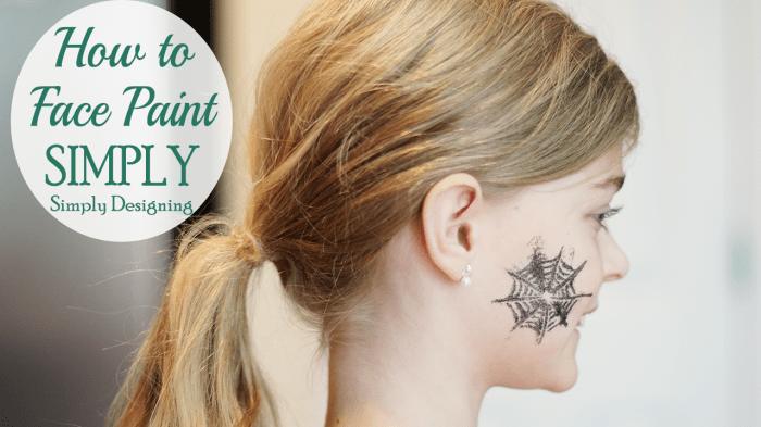 Sparkly Halloween face paint showing a silver glitter spiderweb design on the side of a woman's cheek