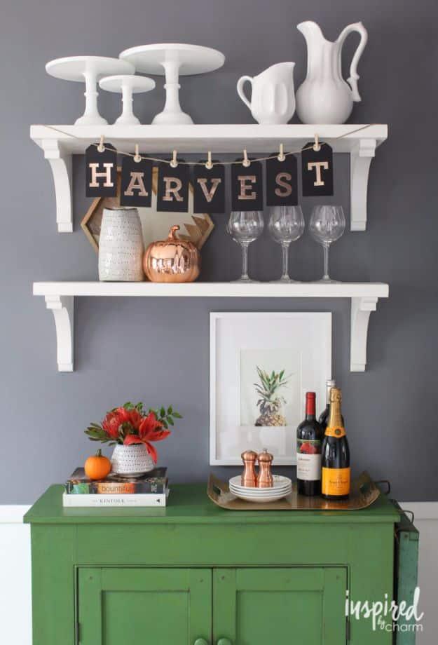 Fall tag banner spelling HARVEST on kraft hang tags clipped to twine with mini clothespins on a white shelf