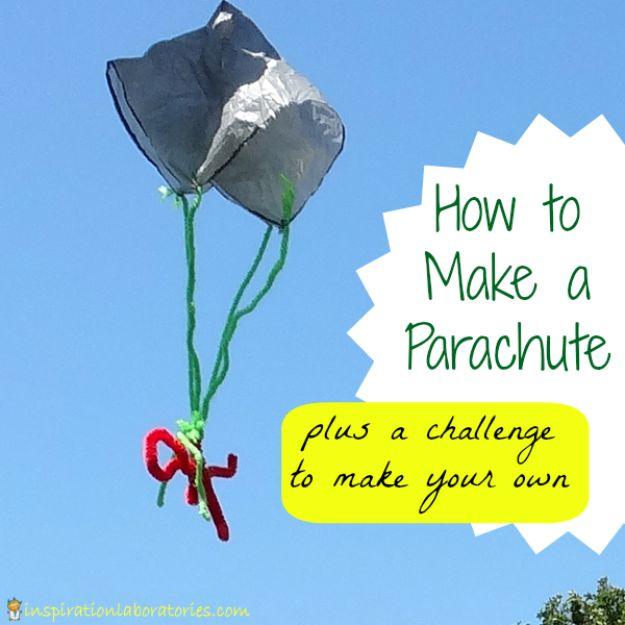 Plastic bag parachute open against a blue sky with green pipe cleaner strings and a red figure hanging below