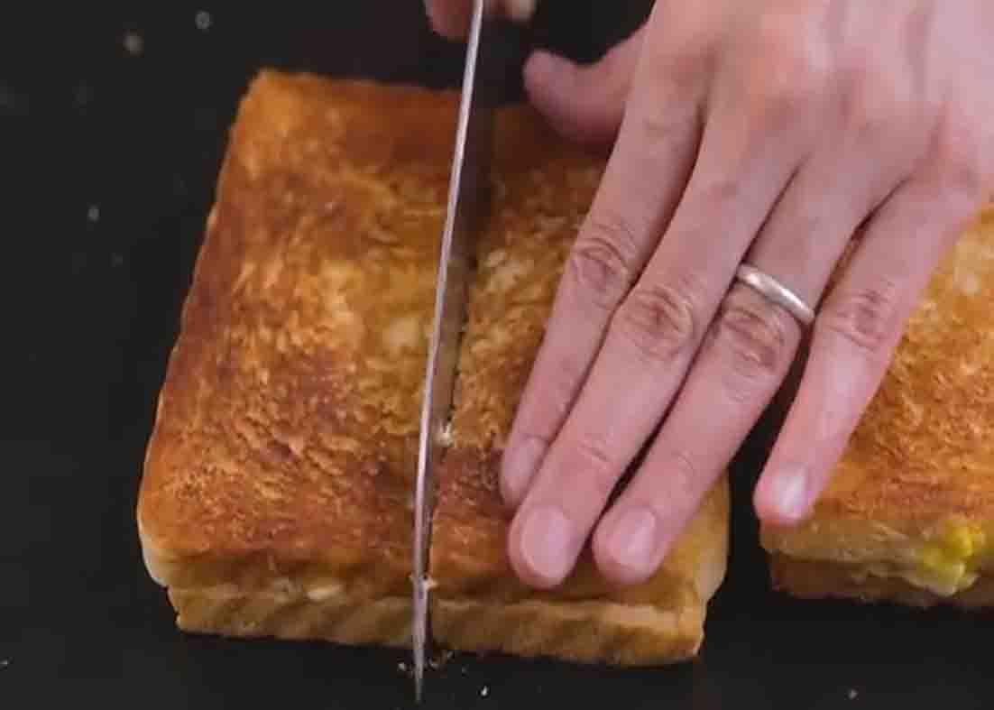 Slicing the egg mayo sandwich before serving