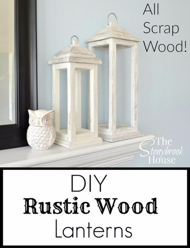 Three tall wood lanterns in weathered gray stand together on a porch step, each holding a lit candle behind glass