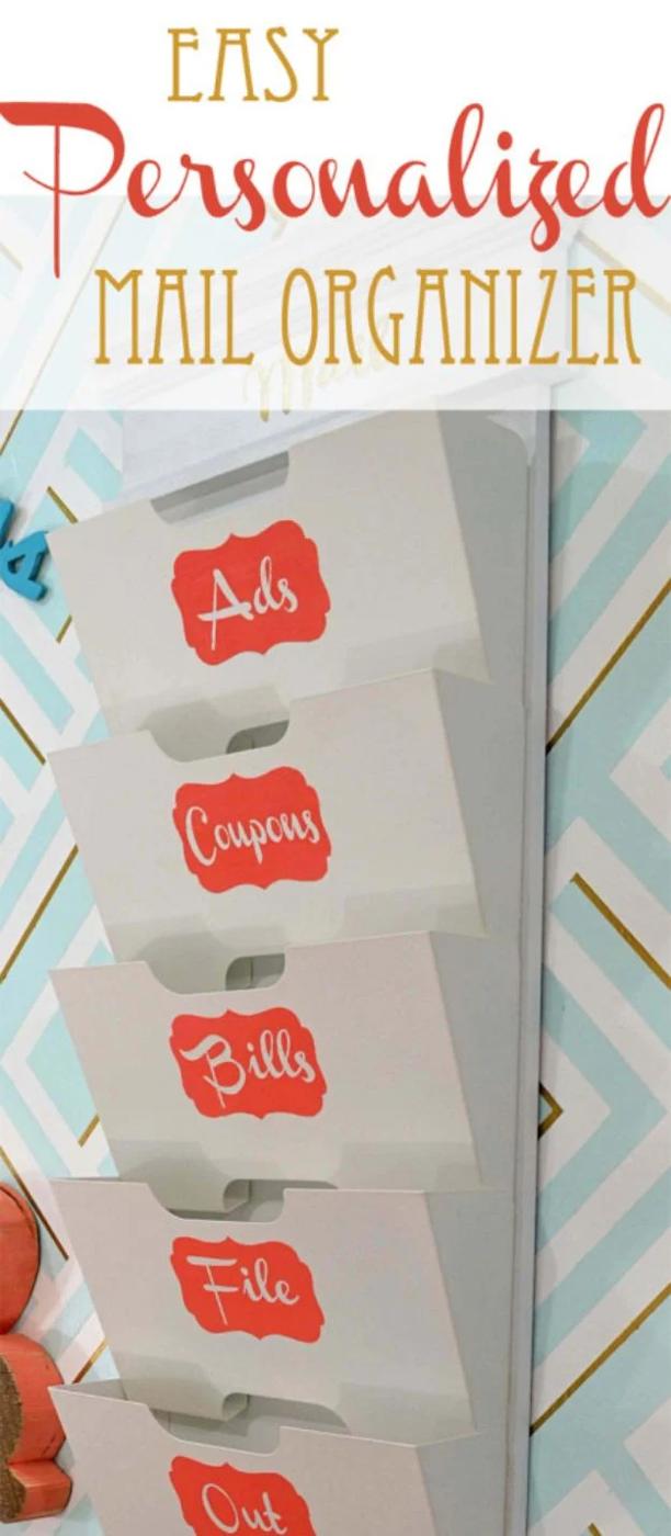 Column of five white metal magazine bins on aqua and gold chevron wallpaper, each labelled in coral for a mail category