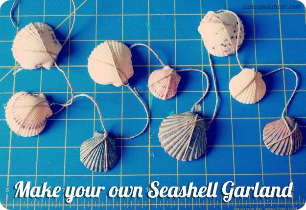 Seashell garland, pale scallop shells wrapped in twine and spaced along a cord on a blue cutting mat