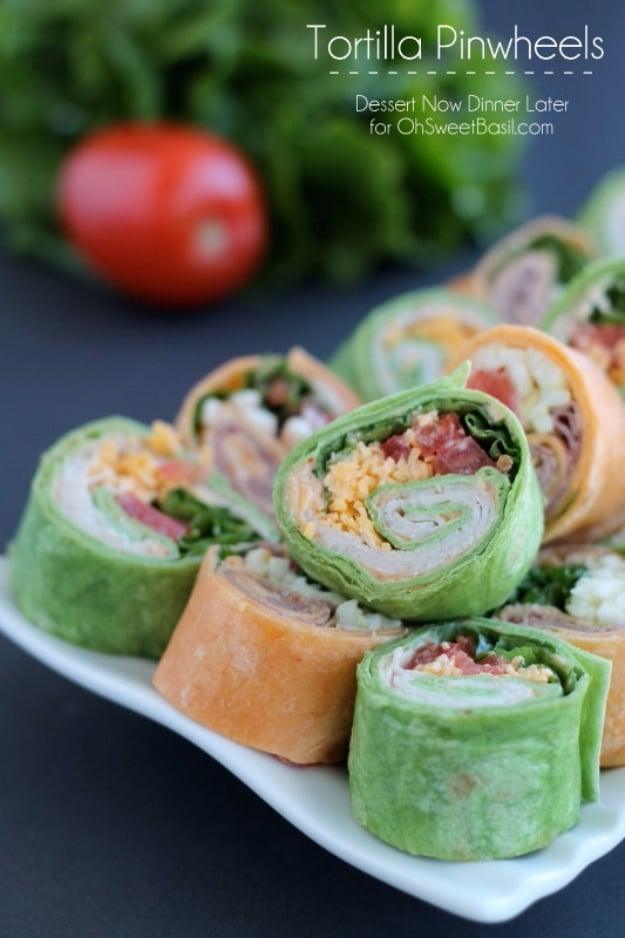 Tortilla pinwheels party appetizer sliced into rounds showing turkey, cheddar, tomato and green lettuce