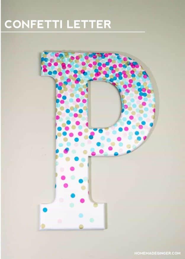DIY confetti letter wall decor, a large white letter P covered in pink, turquoise and gold paper dots on a wall
