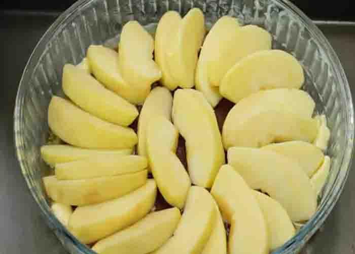 Arranging the apple slices in the bottom of the baking dish