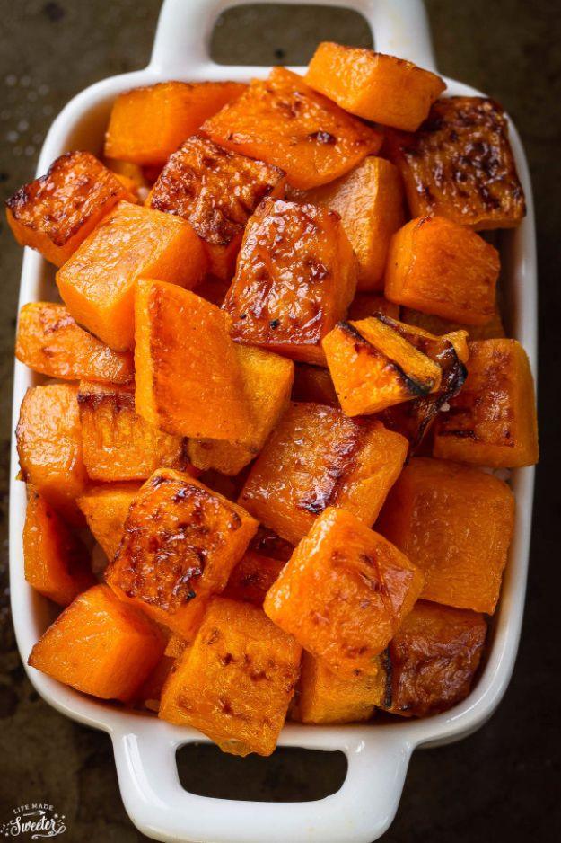 Maple cinnamon roasted butternut squash, caramelized orange squash cubes with browned edges in a white baking dish