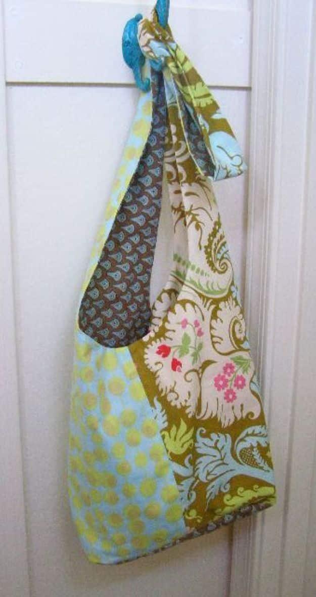 Boho sling bag in an olive and cream damask with an aqua and yellow dot panel, hanging from a white door