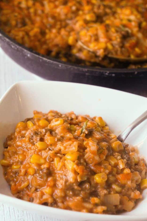 Cheesy tomato ground beef and rice skillet with sweet corn and melted cheddar cheese blanketing the whole top