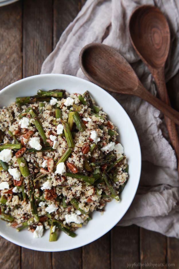 Creamy goat cheese asparagus quinoa salad in a white bowl with quinoa, chopped asparagus and goat cheese