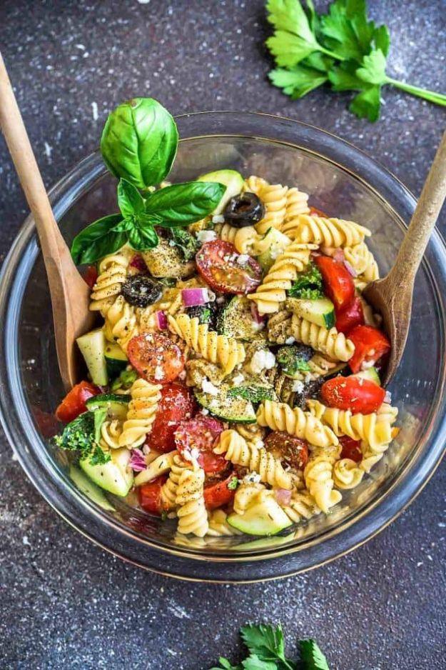 Italian pasta salad with cherry tomatoes, zucchini, black olives, red onion and fresh basil in vinaigrette
