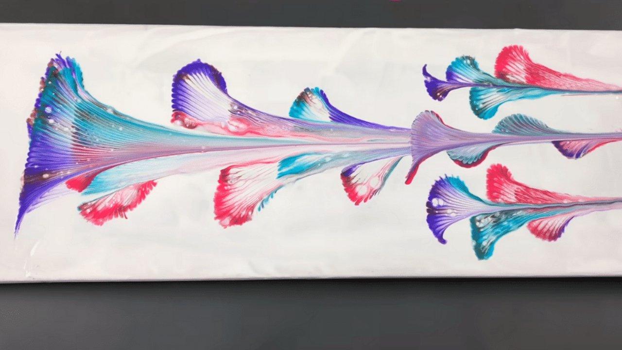 Abstract flowers in purple, pink and teal printed onto a white canvas by dragging a paint loaded metal chain